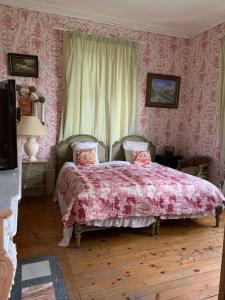 um quarto com uma cama com um edredão rosa em Château de Monteux em La Fouillouse