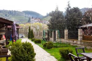 um jardim com parque infantil numa aldeia em Meteor Family Hotel em Chepelare