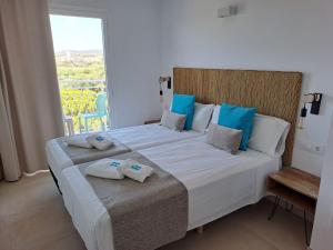 a bedroom with a large bed with towels on it at Bamblue Boutique Apartments in Pineda de Mar