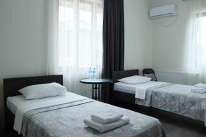 pokój hotelowy z 2 łóżkami i stołem w obiekcie Hotel West Face w Kutaisi