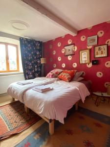 Schlafzimmer mit einem großen Bett mit roten Wänden in der Unterkunft Gite des 2 églises 
