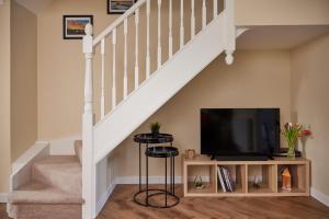 a living room with a staircase with a flat screen tv at Fairburn - DayDream Stays, luxury accomodation for holidays and contractors in Fairburn