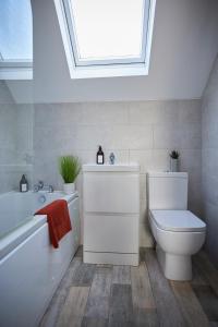 a bathroom with a toilet and a bath tub and a skylight at Fairburn - DayDream Stays, luxury accomodation for holidays and contractors in Fairburn