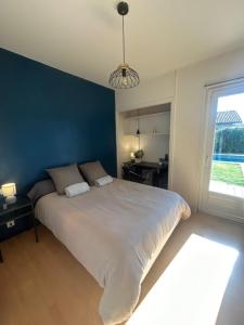 ein Schlafzimmer mit einem großen Bett mit blauer Wand in der Unterkunft la petite bulle in Montagnat