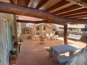 un patio con banco, mesa y sillas en Pensión O Corazón da Ribeira Sacra en La Teijeira