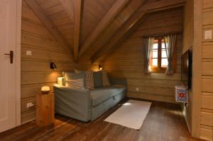 una sala de estar con sofá en una cabaña de madera en Chalupa Daniel, en Ždiar