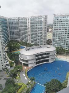 a large building with a swimming pool next to tall buildings at Azure staycation by jane in Manila