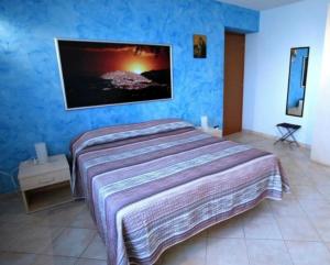 1 dormitorio con 1 cama y TV en la pared en B&B IL GALLETTO R. en Gangi