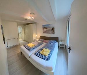 Schlafzimmer mit einem großen Bett mit blauer und weißer Bettwäsche in der Unterkunft Haus Regina in Timmendorfer Strand