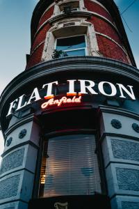 a neon sign on the front of a building at Flat Iron Anfield in Liverpool