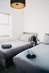 a bedroom with two beds and a chandelier at Flat Iron Anfield in Liverpool