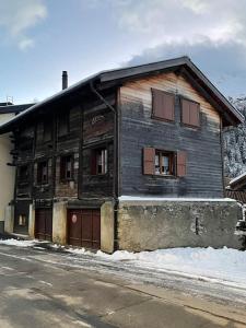 an old wooden house on the side of a street at La Grange à Coco avec jacuzzi in Bourg-Saint-Pierre