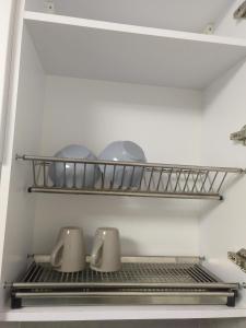 a shelf in a refrigerator with pots and pans at Небольшая, мега уютная квартира in Chişinău