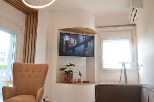 ein Wohnzimmer mit einem Fernseher an der Wand in der Unterkunft KooKai - Luxury Living in Peraia