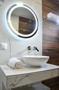 ein Badezimmer mit einem weißen Waschbecken und einem Spiegel in der Unterkunft KooKai - Luxury Living in Peraia
