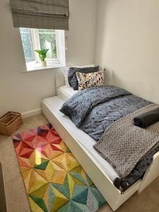 a bedroom with a bed with a colorful rug at Luxury Apartments - MBS Lettings in Bewdley