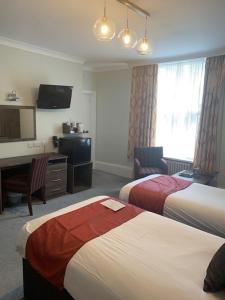 a hotel room with two beds and a television at Marsham Court Hotel in Bournemouth