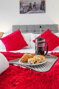 a tray with croissants on a bed with a tea kettle at 2 Bed In Southampton City With Free Parking in Southampton