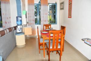 a dining room with a table and chairs and a coffee machine at Enchante Suites Kigali in Kigali