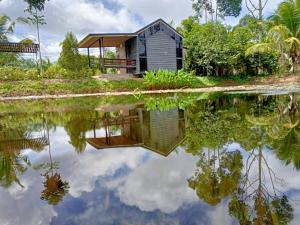 a small house with a reflection in a body of water at เป่าฟู่เฮ้าส์ Bao Fu's House in Chumphon