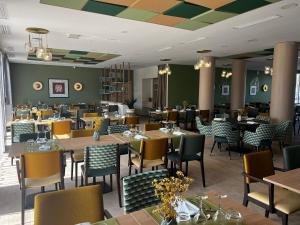 Domitys L'Aubier de Tilia في شاتورينارد: غرفة طعام مع طاولات وكراسي في مطعم
