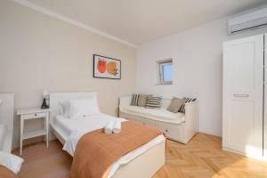 a white bedroom with a bed and a couch at House Leny by IstriaLux in Štokovci +30 photos