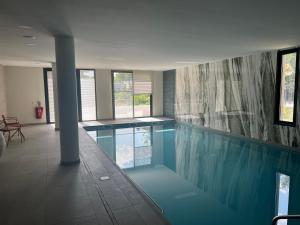 a swimming pool in a building with a pool at Domitys L'Aubier de Tilia in Châteaurenard