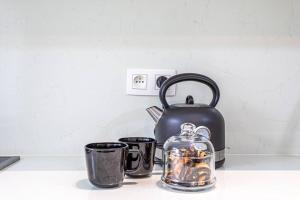 a tea kettle and two cups on a counter at Beautiful studio in Antwerp