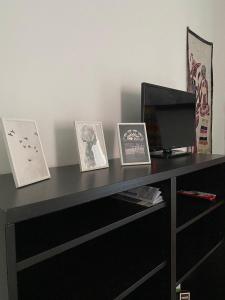 un escritorio negro con tres fotos y un televisor en Dimora Zefiro vacanze, en Gioiosa Marea