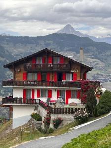 uma casa numa colina com uma montanha ao fundo em Gaby em Grächen