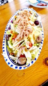 uma salada numa tigela numa mesa de madeira em Caslune 