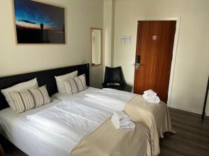 a hotel room with a large bed with towels on it at Hotel Frederikshavn in Frederikshavn