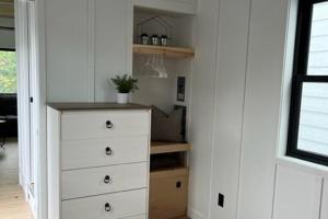 a white dresser in a room with a closet at The Endeavor Tiny Home! in Elizabethtown