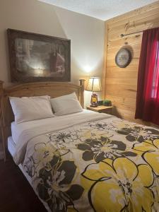 ein Schlafzimmer mit einem Bett und einer Uhr an der Wand in der Unterkunft River Place Condos #206 2BD in Pigeon Forge