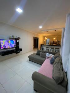 uma sala de estar com um sofá e uma televisão de ecrã plano em casa para alugar em Prado bahia. em Prado