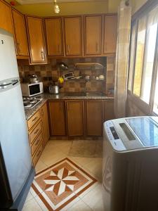 una cucina con armadi in legno e frigorifero di Residence Ohod a Berrechid
