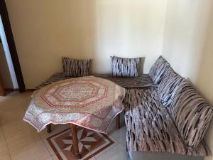a room with a couch and a table with a blanket at Residence Ohod in Berrechid
