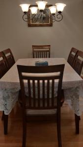uma mesa de jantar com uma toalha de mesa e uma cadeira em The Comfort Stay at City of Pickering em Pickering