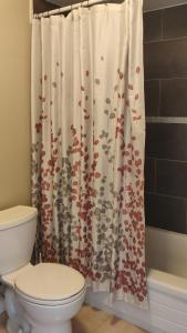 uma casa de banho com um WC e uma cortina de chuveiro em The Comfort Stay at City of Pickering em Pickering