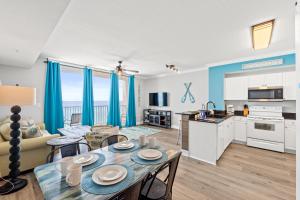 a kitchen and a living room with a table and chairs at Tidewater Beach Resort #614 by Book That Condo in Panama City Beach