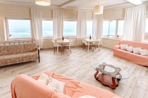 sala de estar con muebles de color naranja y ventanas grandes. en Residencial Real Guest House, en Sintra