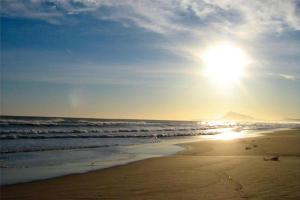 a beach with the sun rising over the ocean at 3 Bed Flat - Sleeps 5 - Wifi in Bellreguart