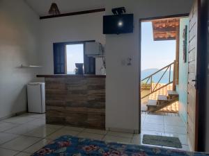 ein Wohnzimmer mit Blick auf einen Balkon in der Unterkunft Chalé & Suítes Mar Aberto in Ilhabela