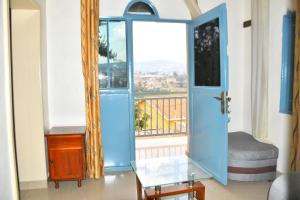 Pokój z niebieskimi drzwiami i balkonem w obiekcie Enchante Suites Kigali w mieście Kigali