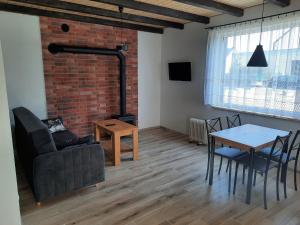 a living room with a table and a brick wall at Domki Gorczyca in Płaska