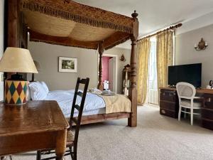 1 dormitorio con cama con dosel, mesa y escritorio en Montigo Resorts, Somerset, en Shepton Mallet