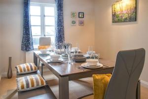 a dining room with a wooden table with chairs at Windrush Lake 88, Waterside in South Cerney