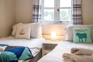 two twin beds in a room with a window at Windrush Lake 88, Waterside in South Cerney