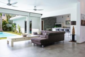 ein Wohnzimmer mit einem Sofa und einem Tisch in der Unterkunft Stylish 4 Bedroom Modern Villa Design, Walking Distance From The Beach in Jan Thiel