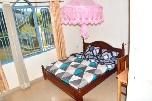 sypialnia z łóżkiem i oknem w obiekcie Enchante Suites Kigali w mieście Kigali